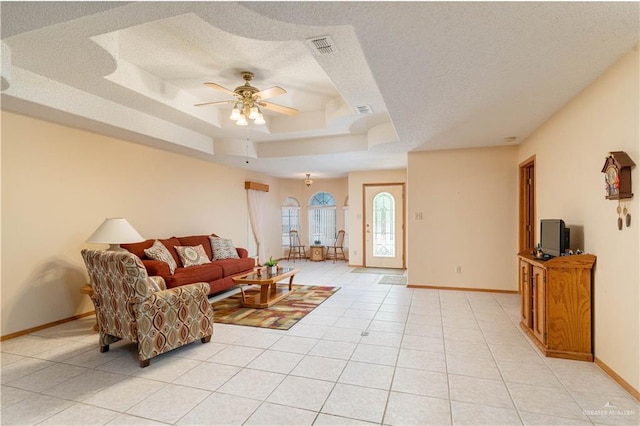 1717 Sun St, Mission, TX 78572 - living area with baseboards, a ceiling fan, a raised ceiling, a textured ceiling, and light tile patterned floors