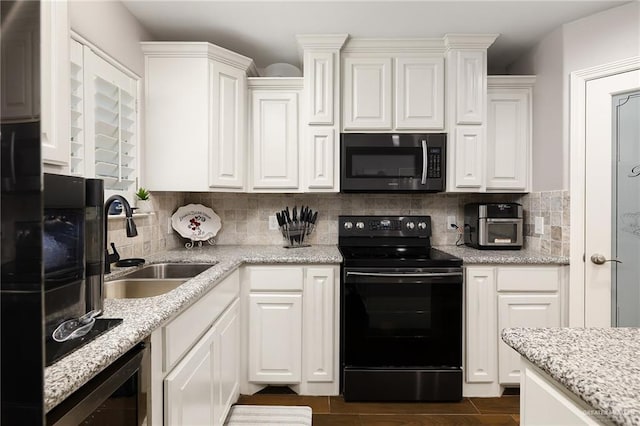 kitchen featuring white cabinetry, stainless steel microwave, electric range, and a sink