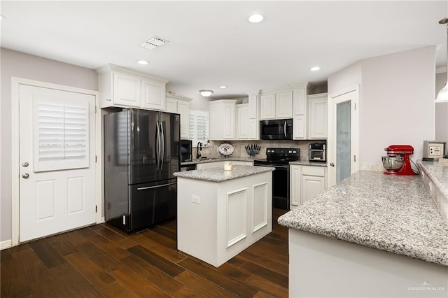 kitchen featuring a sink, black appliances, dark wood-style floors, and white cabinetry