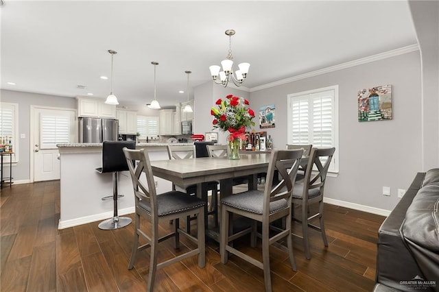 dining area featuring dark wood-type flooring, a notable chandelier, baseboards, and ornamental molding