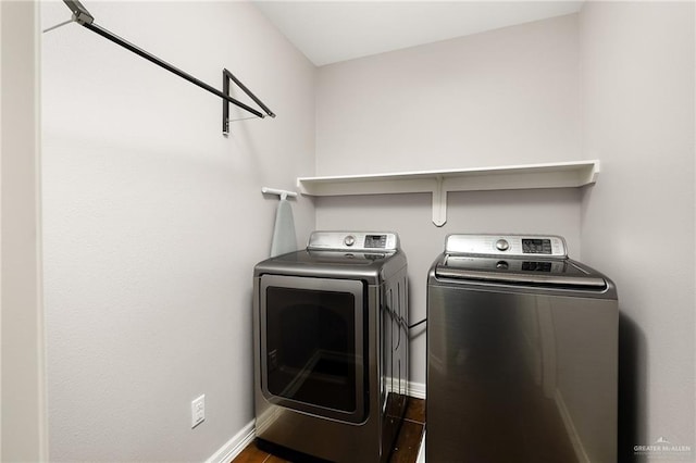 washroom featuring washing machine and clothes dryer, laundry area, and baseboards