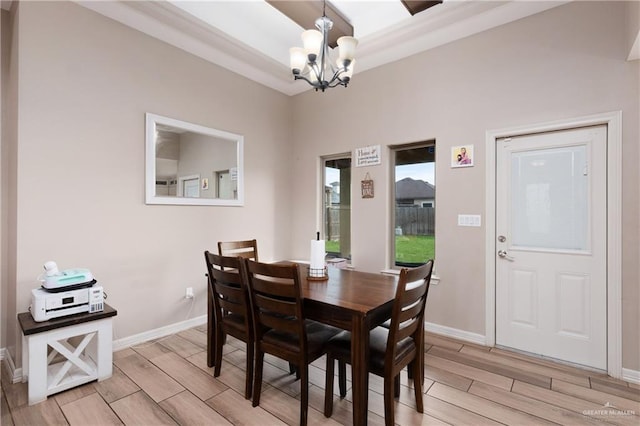 dining space with a chandelier, wood tiled floor, and baseboards