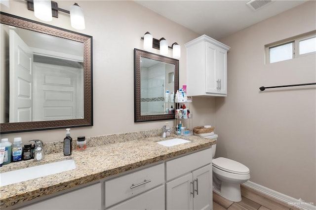 bathroom featuring visible vents, a sink, baseboards, and double vanity