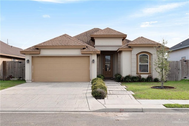 view of front facade with an attached garage, fence, concrete driveway, and stucco siding