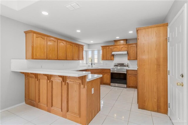 2407 Flores Dr, Mission, TX 78574 - kitchen featuring stainless steel electric range oven, a peninsula, a sink, a breakfast bar area, and light countertops