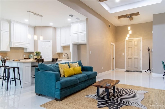 living room featuring ceiling fan and sink