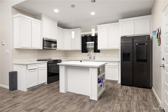 kitchen featuring pendant lighting, hardwood / wood-style flooring, white cabinets, and appliances with stainless steel finishes