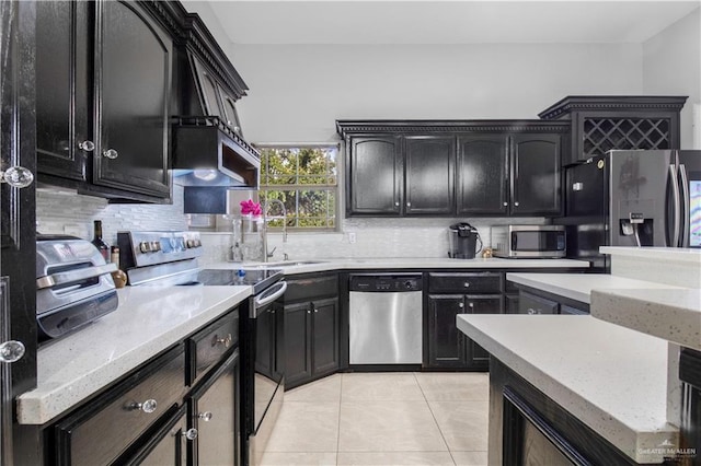 kitchen featuring sink, tasteful backsplash, light tile patterned floors, appliances with stainless steel finishes, and wall chimney range hood