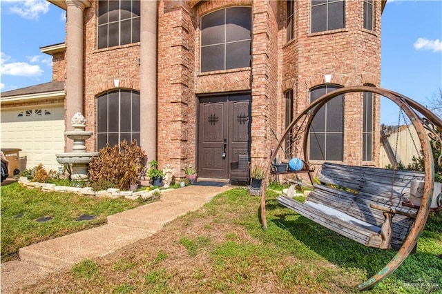 entrance to property featuring a garage and a yard