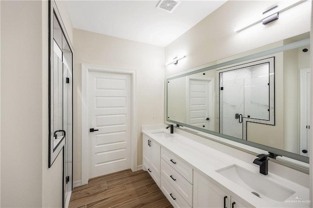 bathroom featuring vanity, wood-type flooring, and an enclosed shower