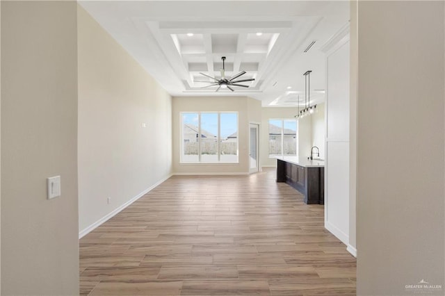 corridor featuring light hardwood / wood-style floors, sink, beam ceiling, and coffered ceiling