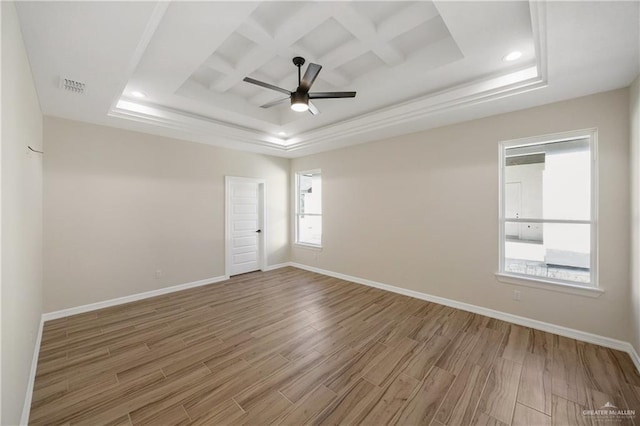 spare room featuring coffered ceiling, ceiling fan, wood-type flooring, and a tray ceiling