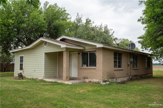 16877 Borchardt St, Harlingen, TX 78552 - view of front of home with a front lawn, a chimney, and brick siding