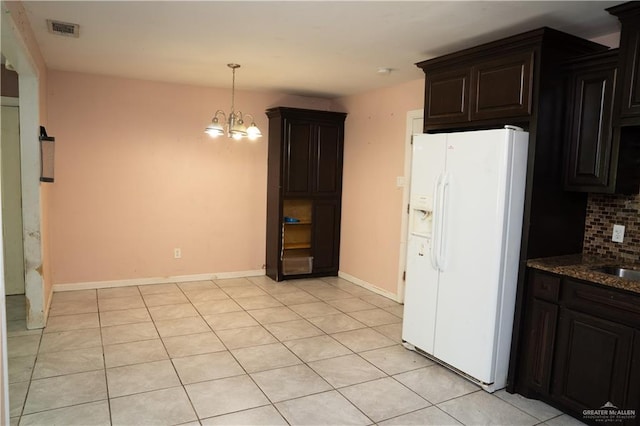 16877 Borchardt St, Harlingen, TX 78552 - kitchen featuring white fridge with ice dispenser, stone countertops, tasteful backsplash, a chandelier, and light tile patterned floors