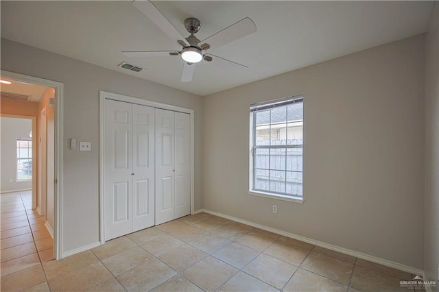 unfurnished bedroom featuring light tile patterned flooring, ceiling fan, and a closet