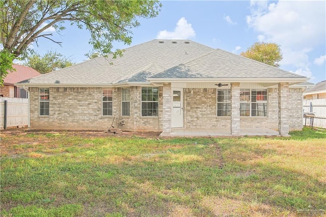 back of property with a yard and a patio area