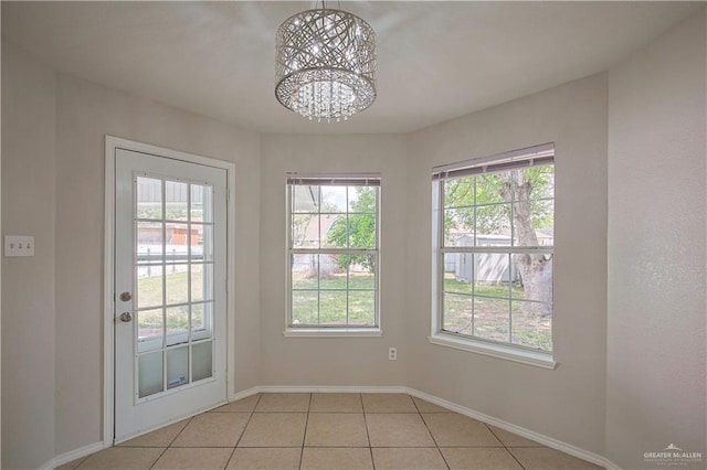 entryway featuring an inviting chandelier, light tile patterned floors, and a healthy amount of sunlight