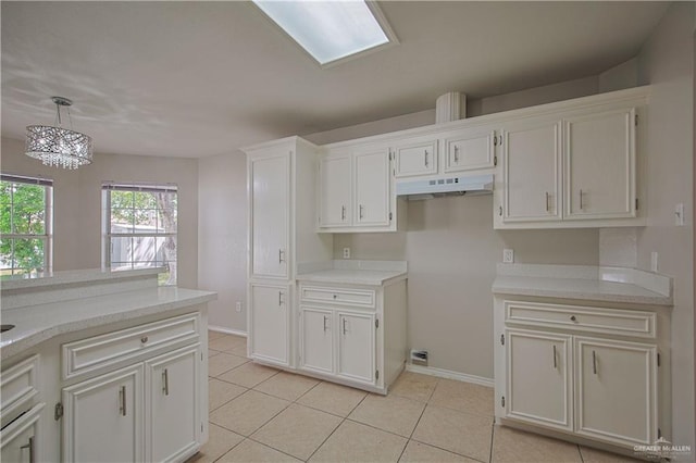 kitchen with hanging light fixtures, light tile patterned floors, and white cabinets