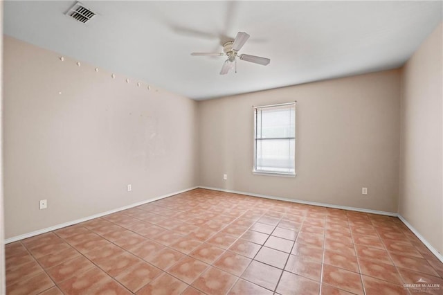 tiled spare room with ceiling fan