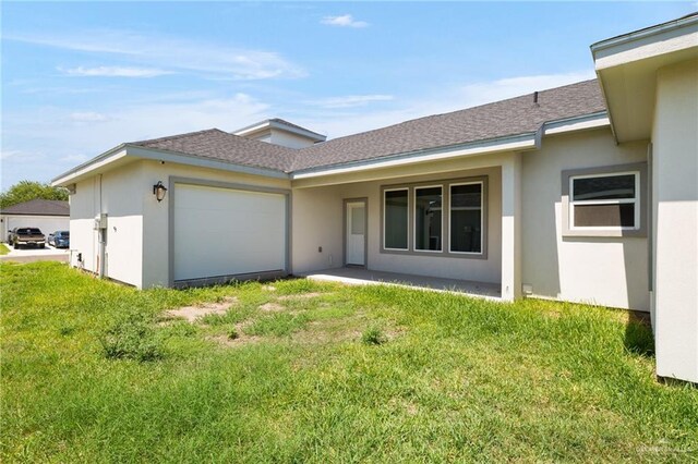 1421 Franklin Ave, Alton, TX 78573 - view of front of home with an attached garage, a front lawn, stucco siding, and a shingled roof