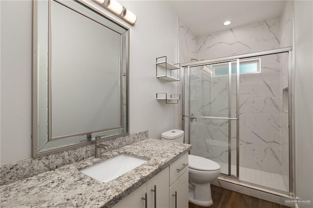 1421 Franklin Ave, Alton, TX 78573 - full bathroom featuring toilet, a marble finish shower, vanity, wood finished floors, and recessed lighting