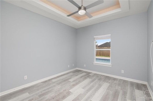 5904 N Dodger St, Pharr, TX 78577 - unfurnished room with a tray ceiling, light wood-style flooring, ceiling fan, and baseboards
