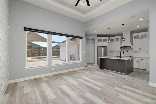 5904 N Dodger St, Pharr, TX 78577 - kitchen with premium range hood, light countertops, white cabinetry, light wood-style flooring, and recessed lighting