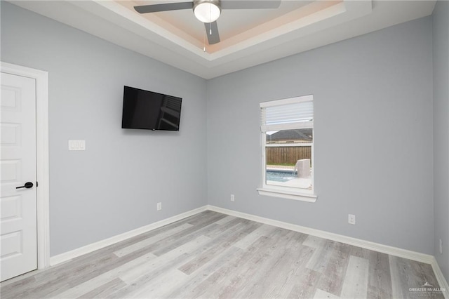 5904 N Dodger St, Pharr, TX 78577 - empty room with light wood-style floors, ceiling fan, a raised ceiling, and baseboards