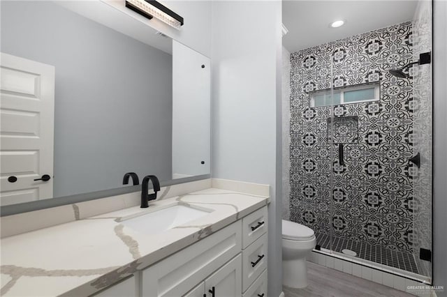 5904 N Dodger St, Pharr, TX 78577 - bathroom with a shower stall, toilet, vanity, wood finished floors, and recessed lighting