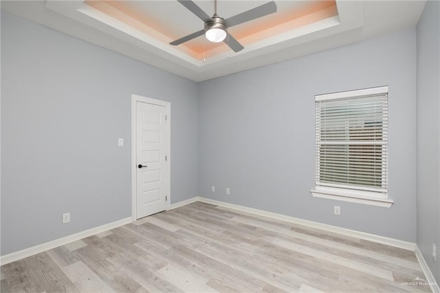5904 N Dodger St, Pharr, TX 78577 - unfurnished room with a tray ceiling, light wood-style flooring, a ceiling fan, and baseboards