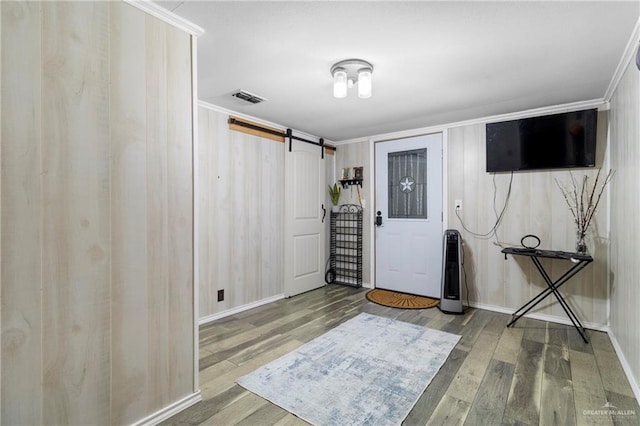 3204 Barbara Ln, Edinburg, TX 78542 - entryway featuring a barn door, wood finished floors, baseboards, and crown molding