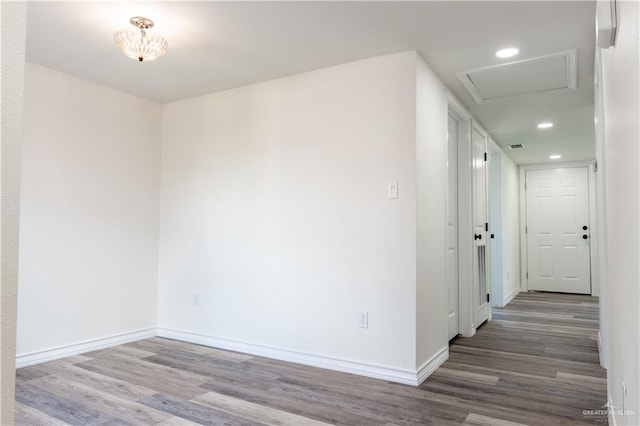 empty room featuring hardwood / wood-style flooring and an inviting chandelier