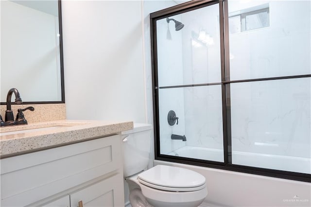 full bathroom with vanity, toilet, and combined bath / shower with glass door