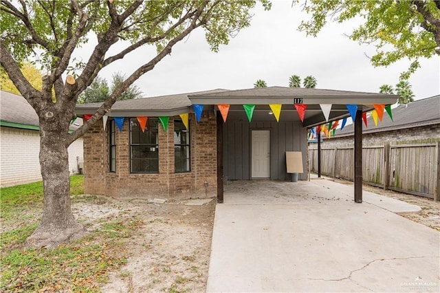 117 Keystone St, Mission, TX 78572 - view of front of home with fence, board and batten siding, brick siding, driveway, and an attached carport