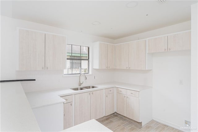 117 Keystone St, Mission, TX 78572 - kitchen featuring a sink, light brown cabinets, light wood finished floors, light countertops, and decorative backsplash