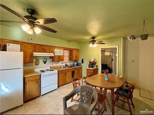 711 Marcos Hinojosa Ave, Hebbronville, TX 78361 - kitchen featuring white appliances, ceiling fan, under cabinet range hood, and brown cabinets