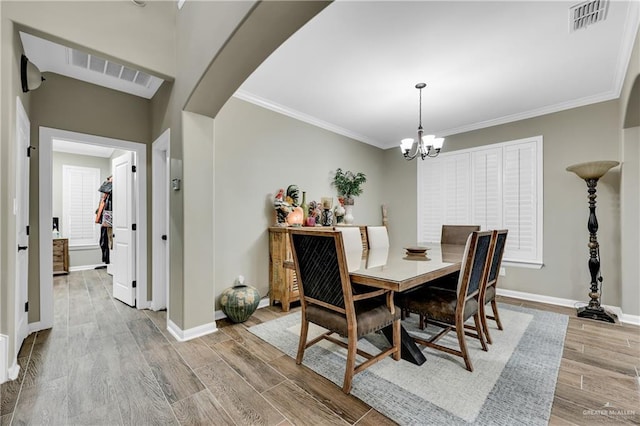 dining room featuring a notable chandelier, crown molding, and light hardwood / wood-style floors