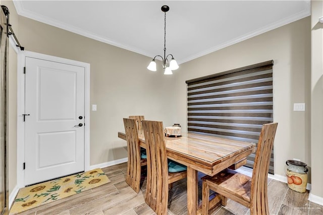 dining area with light hardwood / wood-style flooring, ornamental molding, a barn door, and a chandelier