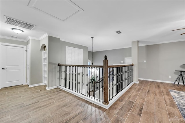 corridor featuring crown molding and light hardwood / wood-style flooring