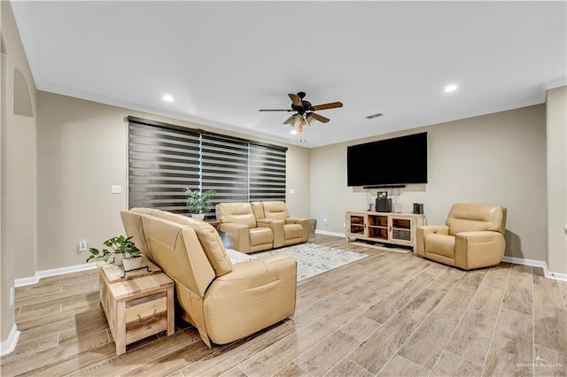 living room featuring crown molding, light hardwood / wood-style floors, and ceiling fan