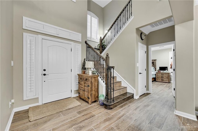 entrance foyer featuring hardwood / wood-style flooring and a towering ceiling