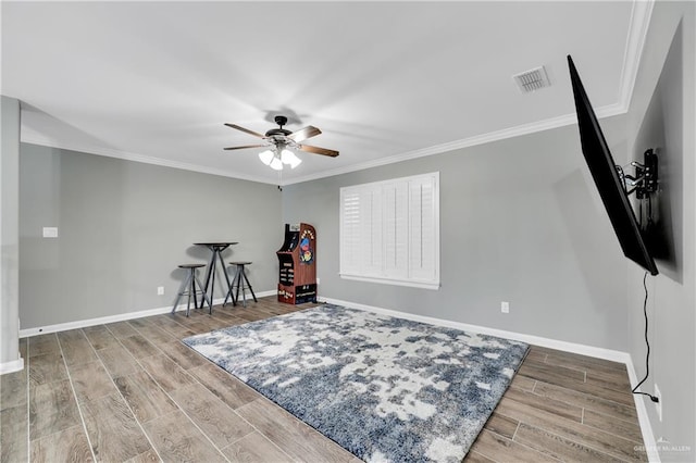 interior space with ornamental molding and ceiling fan