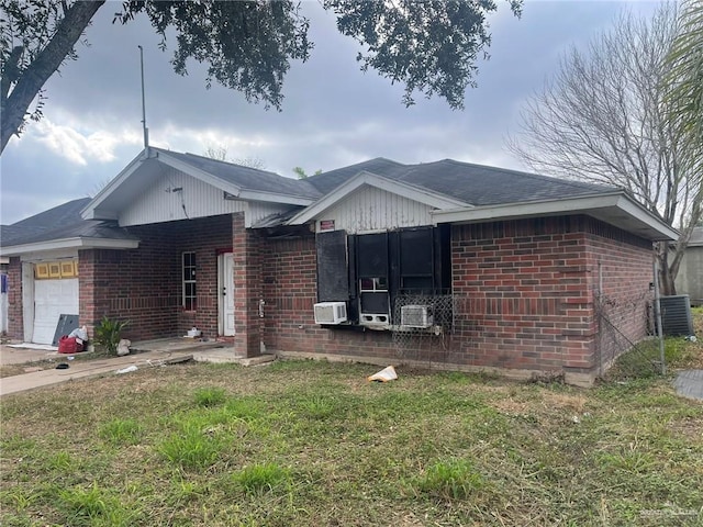 view of side of property featuring central AC, a garage, and a lawn