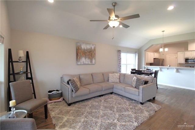 living room with ceiling fan with notable chandelier, lofted ceiling, and dark wood-type flooring