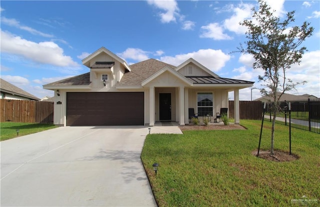 view of front of home featuring covered porch, a garage, and a front yard