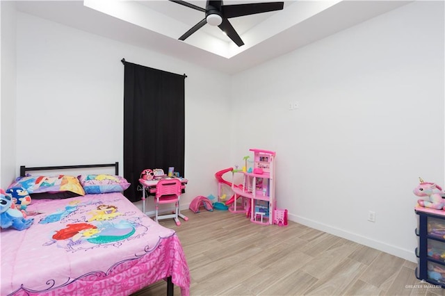 bedroom featuring a ceiling fan, baseboards, and wood finished floors