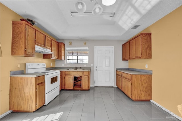 1101 Boston St, Edinburg, TX 78541 - kitchen with white range with electric stovetop, a sink, light countertops, under cabinet range hood, and visible vents