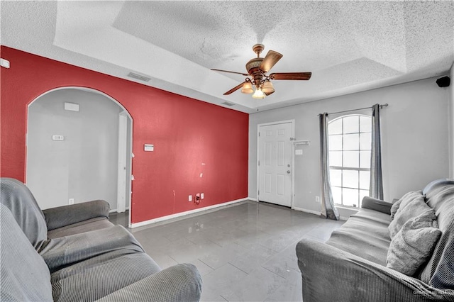 1101 Boston St, Edinburg, TX 78541 - living room featuring ceiling fan, a tray ceiling, a textured ceiling, and visible vents