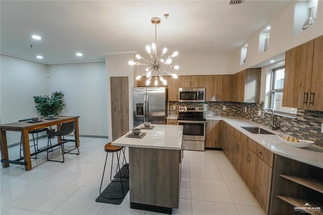 3302 S Sugar Rd Unit E, Edinburg, TX 78539 - kitchen featuring stainless steel appliances, a sink, brown cabinets, decorative backsplash, and a center island