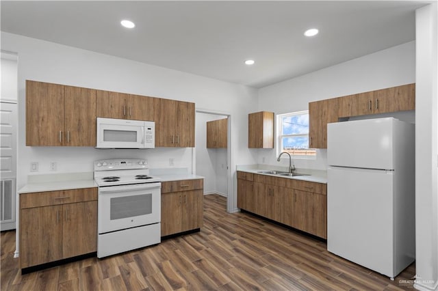 kitchen featuring sink, dark wood-type flooring, and white appliances